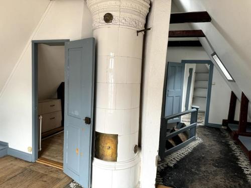 een kamer met een zuil met een deur en een trap bij Historisk takvåning i gamla stan in Stockholm