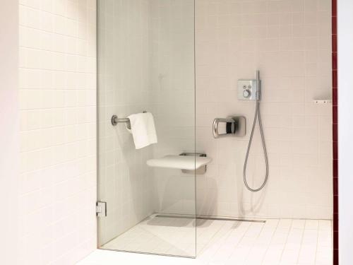 uma casa de banho com um chuveiro e uma porta de vidro em Mama Shelter Luxembourg em Luxemburgo