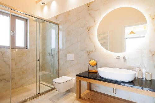 een badkamer met een wastafel en een glazen douche bij Villa Tila by Villa Plus in Agnítsini