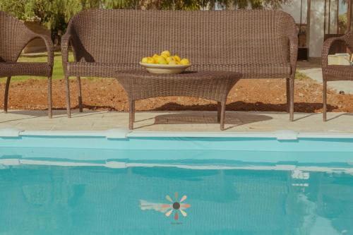 un bol de fruta sentado en una mesa junto a una piscina en Agriturismo tenuta Margherita, en Torre Lapillo