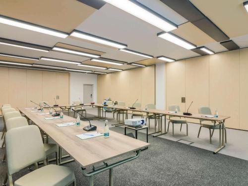 a large room with a long table and chairs at ibis Timisoara City Center in Timişoara