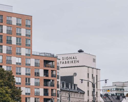 un edificio alto con una señal para la sexta academia en Story Hotel Signalfabriken, part of JdV by Hyatt, en Sundbyberg