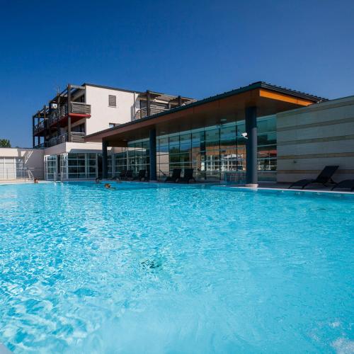 une grande piscine devant un immeuble dans l'établissement Le jardin de l'Ostal, à Casteljaloux