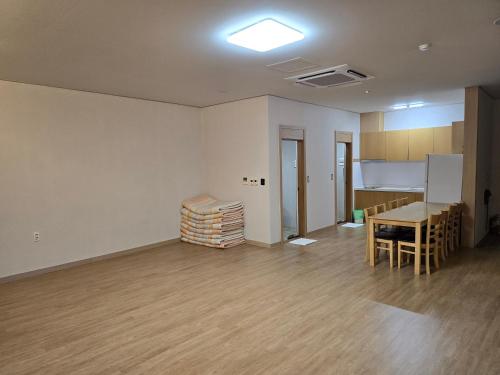 Yeosu Narsha Hotel في يوسو: غرفة فارغة مع طاولة ومطبخ