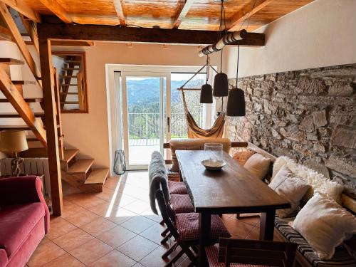 sala de estar con mesa y pared de piedra en Casa Rural As Bodegas - Boal, en Boal