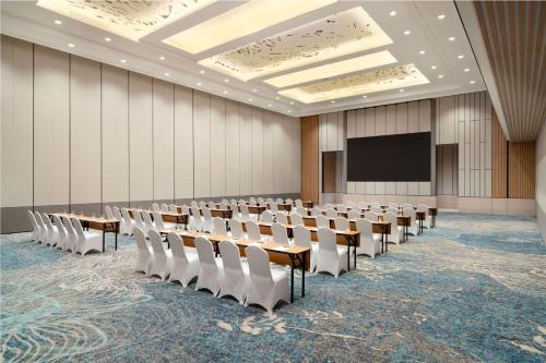 a conference room with tables and chairs and a screen at DoubleTree by Hilton Jakarta Bintaro Jaya in Serpong