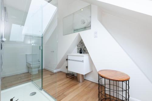 a bathroom with a shower and a sink and a stool at 23 Wharton Road in Oxford