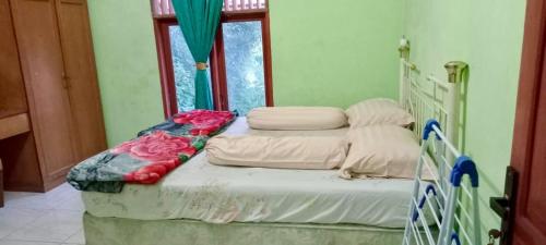 Gulta vai gultas numurā naktsmītnē Buhit Guest House Samosir