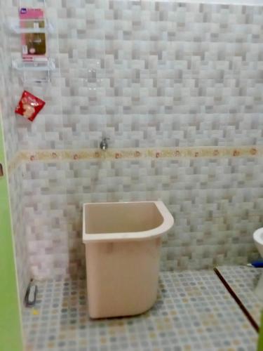 a bathroom with a white toilet in a room at Buhit Guest House Samosir in Pangururan
