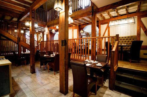 a restaurant with wooden walls and tables and chairs at Heritage Park Pontypridd, Trademark Collection by Wyndham in Pontypridd