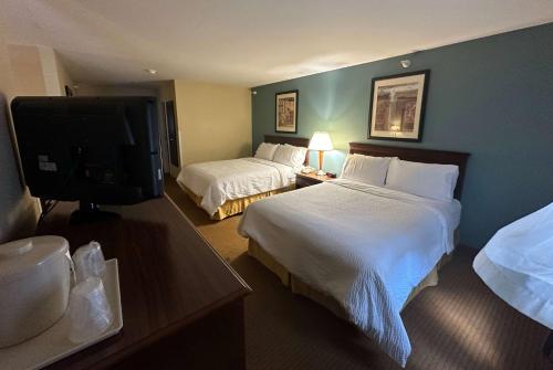 a hotel room with two beds and a flat screen tv at Wingate by Wyndham Newell in Newell