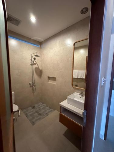 a bathroom with a sink and a shower and a mirror at Sekuta 36 in Sanur