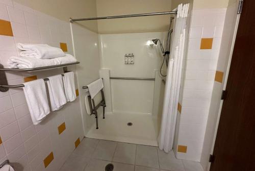 ein Bad mit einer Dusche, einem WC und Handtüchern in der Unterkunft Wingate by Wyndham Newell in Newell