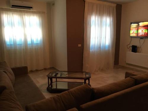 a living room with a couch and a coffee table at 3 Bedrooms appartment in Nabeul