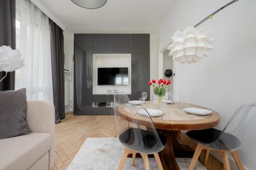 ein Wohnzimmer mit einem Tisch und einem Sofa in der Unterkunft Beautiful & Modern Apartment near the City Center by Renters in Warschau