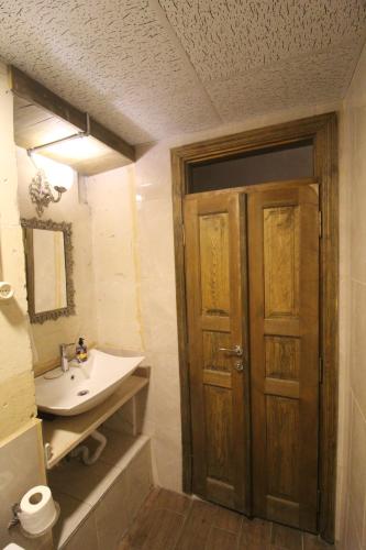 een badkamer met een wastafel en een houten deur bij aynur hanım konağı butik otel in Şahinbey