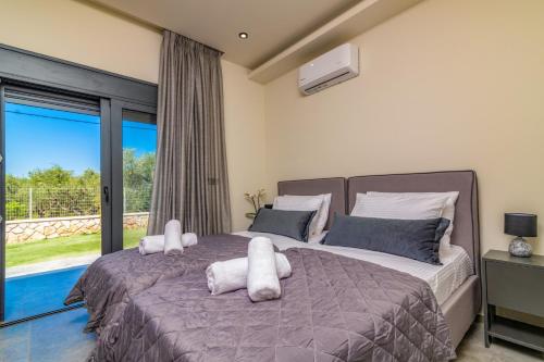 a bedroom with a large bed with white pillows at Villa Casa Liveris by Villa Plus in Akrotiri