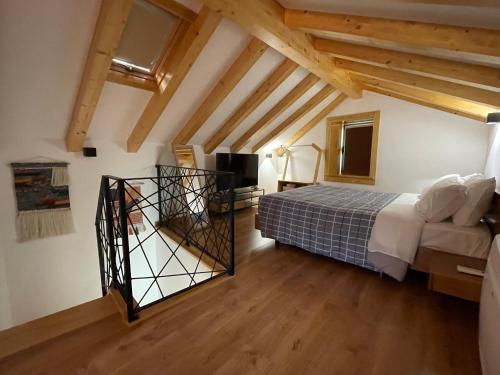 1 dormitorio con 1 cama en una habitación con techos de madera en Dona Irene AL en Manteigas