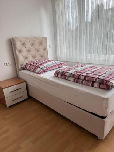 a bed in a room with a window and a bedskirtspectspects at Pension - Panorama in Gundelsheim