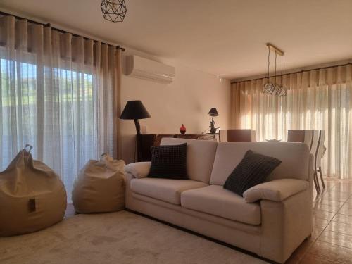a living room with a white couch in front of a window at Minho House in Vieira do Minho