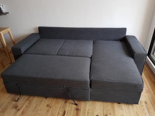 - un canapé noir dans le salon dans l'établissement Magnifique Studio grande terrasse 50 m de la plage, à Lacanau-Océan