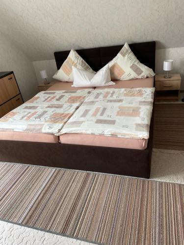 łóżko w pokoju z dwoma stolikami nocnymi i dwoma stołami w obiekcie Zimmervermietung im Eigenheim w mieście Göda