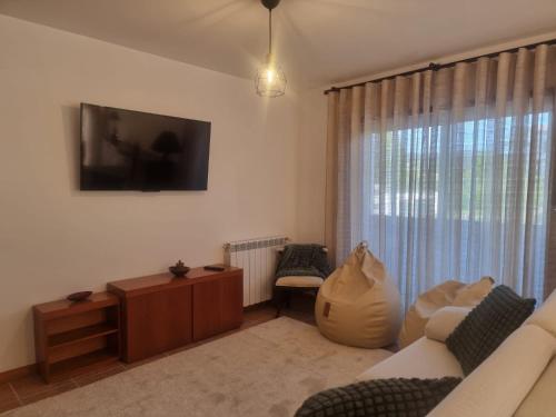 a living room with a couch and a tv on the wall at Minho House in Vieira do Minho