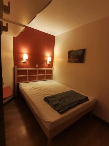 - un lit dans une chambre avec deux lumières sur le mur dans l'établissement Magnifique appartement vue mer avec piscine, à Saint-Raphaël