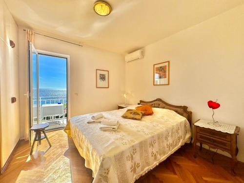 a bedroom with a bed and a large window at Sun Rose Apartments Sveti Stefan in Sveti Stefan