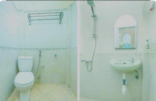 a white bathroom with a toilet and a sink at Senaz Guesthouse in Mataram