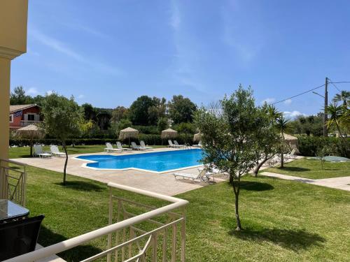 vistas a una piscina en un patio en Mythos apts rentit en Agios Stefanos