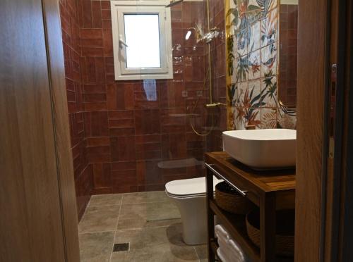 a bathroom with a sink and a toilet and a window at Vivis Hub in Argostoli