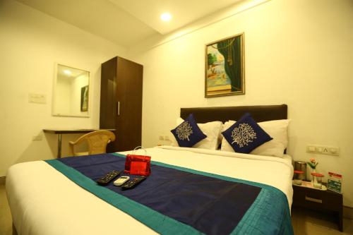 una camera d'albergo con un letto con una scatola rossa di OYO NIMALAN RESIDENCY a Chennai