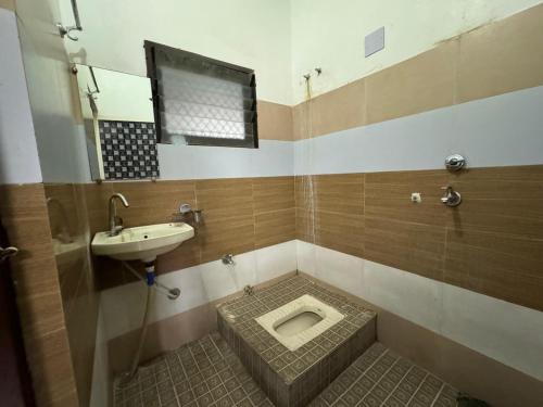 a bathroom with a toilet and a sink at Paarijat PG in Udaipur
