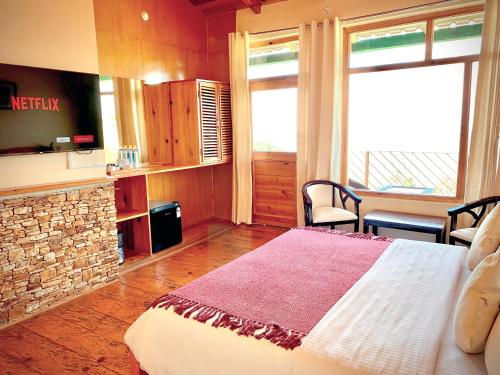 a bedroom with a large bed and a fireplace at Yak and Yeti Inn in Rānīkhet