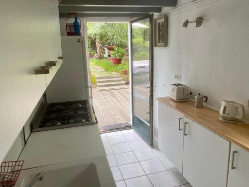 une cuisine avec une porte menant à une terrasse dans l'établissement Maison de charme vue sur port, à Capbreton