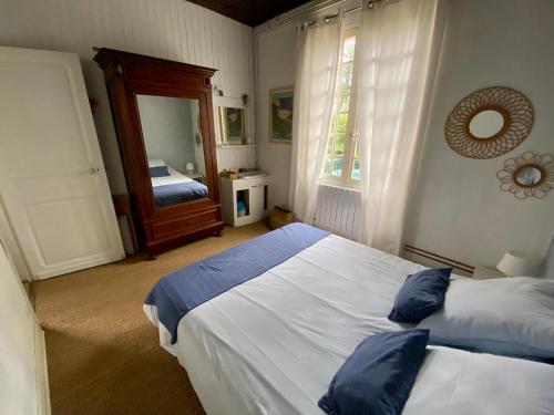 une chambre avec deux lits et un miroir dans l'établissement Maison de charme vue sur port, à Capbreton