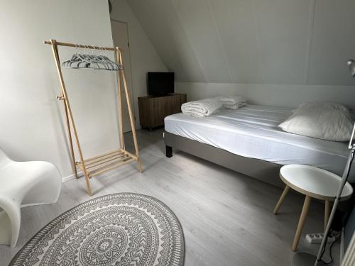 a bedroom with a bed and a chair and a rug at Kustverhuur, Park Schoneveld, Stern 204 in Breskens