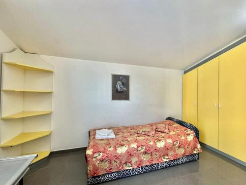 a small bedroom with a bed and yellow cabinets at Sun Rose Apartments Sveti Stefan in Sveti Stefan