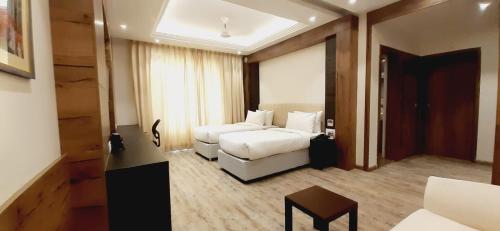 a hotel room with a bed and a couch at The Utopia Resort Sanchi in Sānchi