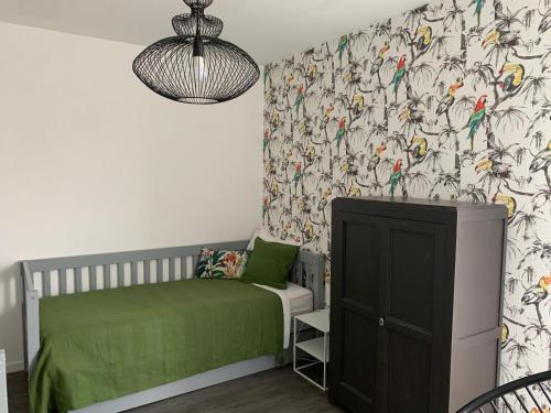 um quarto para crianças com uma cama verde e papel de parede para pássaros em Place verte 2302 em Lille