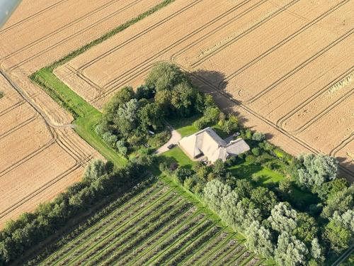 an aerial view of a farm house in a field at Sibyllenhof, Denkmalgeschütztes Reetdachanwesen in ruhiger Alleinlage in Siekbüll