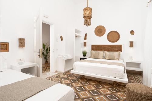a white room with two beds and a bathroom at Semiramis Guesthouse in Adamas