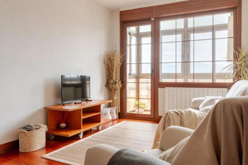 a living room with two chairs and a television at BILBAO COSTA VASCA apartamento entero 3 Dormitorios 4 camas WIFI 5G in Leioa