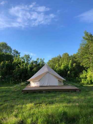 une tente blanche au milieu d'un champ dans l'établissement Kihnu home - Sepa talu, à Rootsiküla