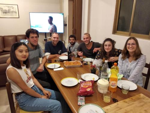 un grupo de personas sentadas alrededor de una mesa en travel to meet new friends new loves - age limit 18-40 - checkin Via Roma 59A en Palermo