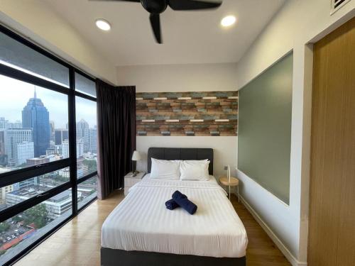 a bedroom with a bed and a large window at Anggun Suite KL in Kuala Lumpur