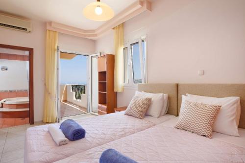 AsgourouにあるVilla Helios Rodos by Villa Plusの青い枕が付いた大きなベッドのある寝室