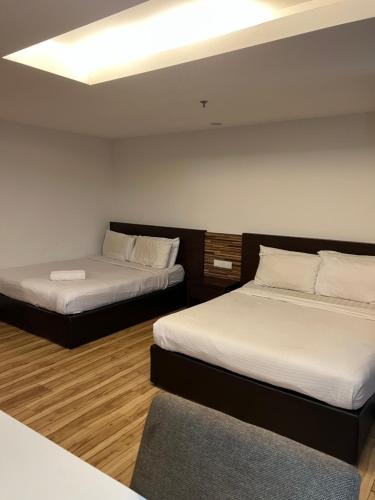 Habitación con 2 camas y sofá. en Studio Exclusive (Kota Bharu City Point), en Kota Bharu