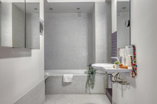 ein weißes Badezimmer mit einer Badewanne und einem Waschbecken in der Unterkunft Stunning Flat with Balcony - Boulogne / Paris 16 in Boulogne-Billancourt